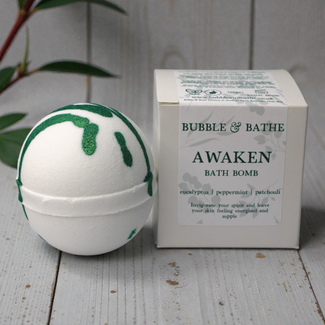 Large white and green Awaken bath bomb fizzing in the water releasing a sharp, revitalising fragrance. 